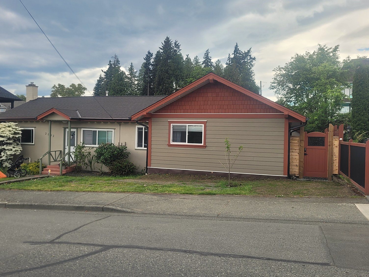 Finished three-bedroom home addition in Chemainus with matched siding, trim, roofline, and custom side gate.