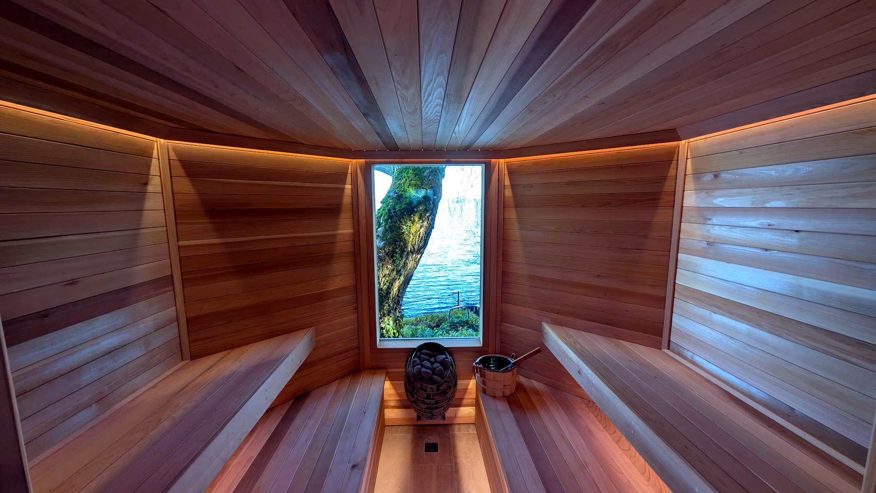 Finished clear cedar sauna interior with panoramic waterfront feature window.