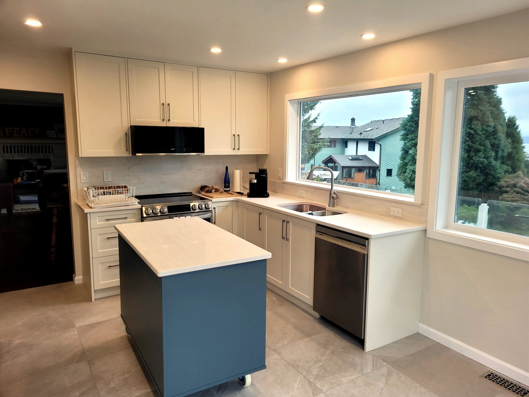Bright custom kitchen renovation with enlarged window openings and improved natural light throughout the space.