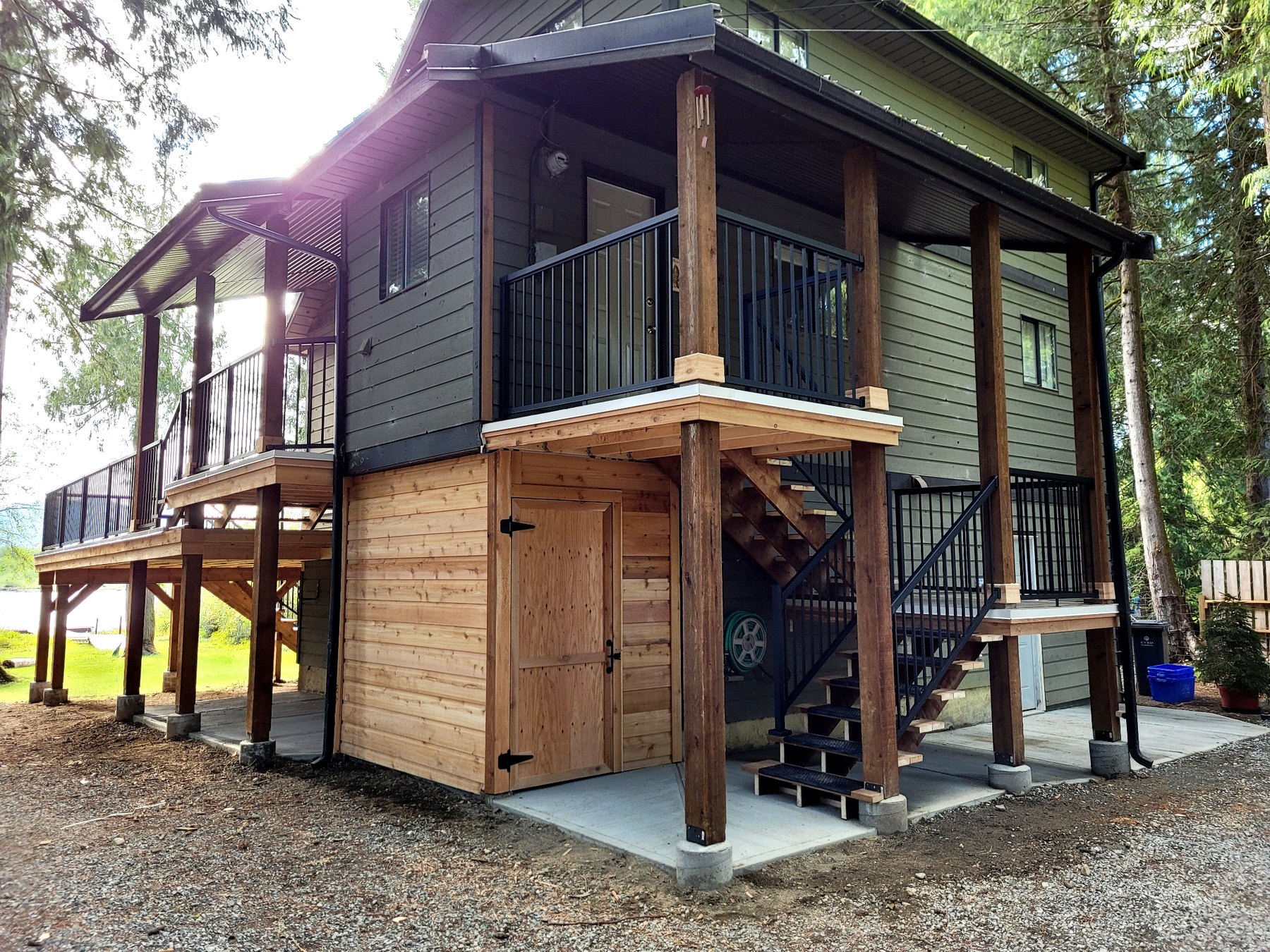 Custom front entry rebuild featuring a new two-tier cedar access deck, covered landing, integrated stair system, and enclosed under-deck storage.